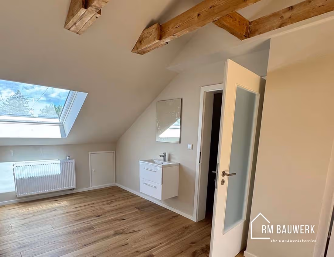 Dachgeschoss mit Dachfenster, Waschbereich und Holzboden nach der Renovierung