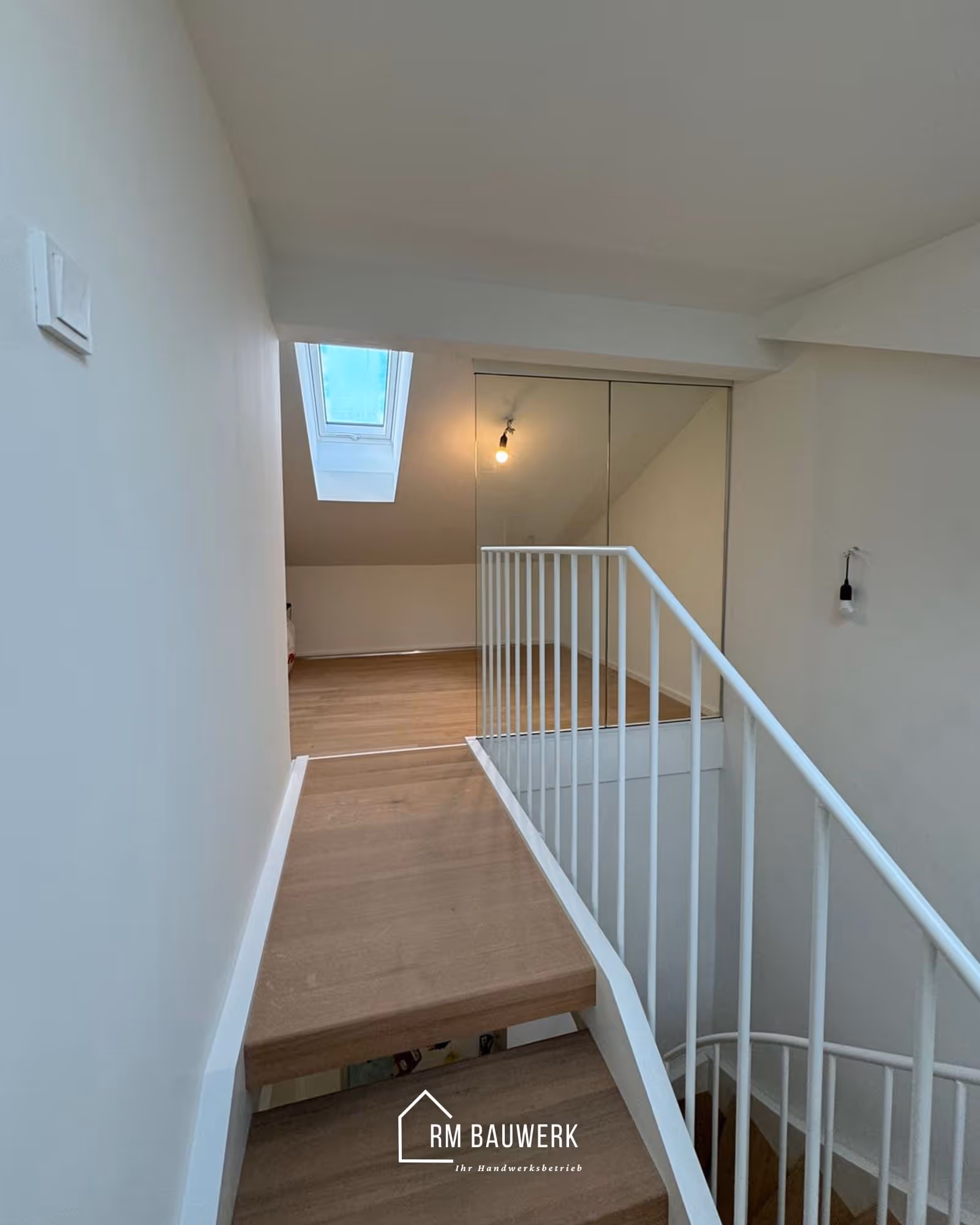 Galerie mit weißem Geländer und Holzboden nach dem Dachgeschossausbau