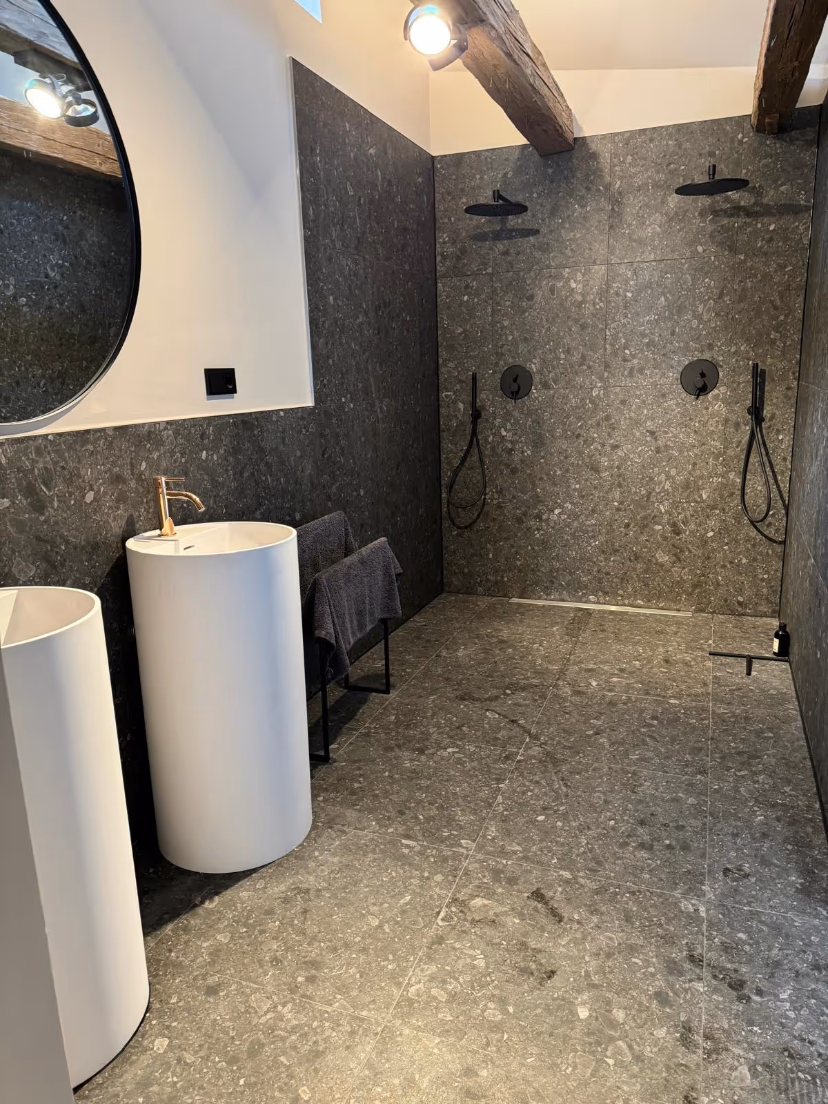 Bad in der sanierten Scheune in Augsburg mit bodengleicher Doppeldusche, Wänden in Steinoptik und freistehendem Waschbecken