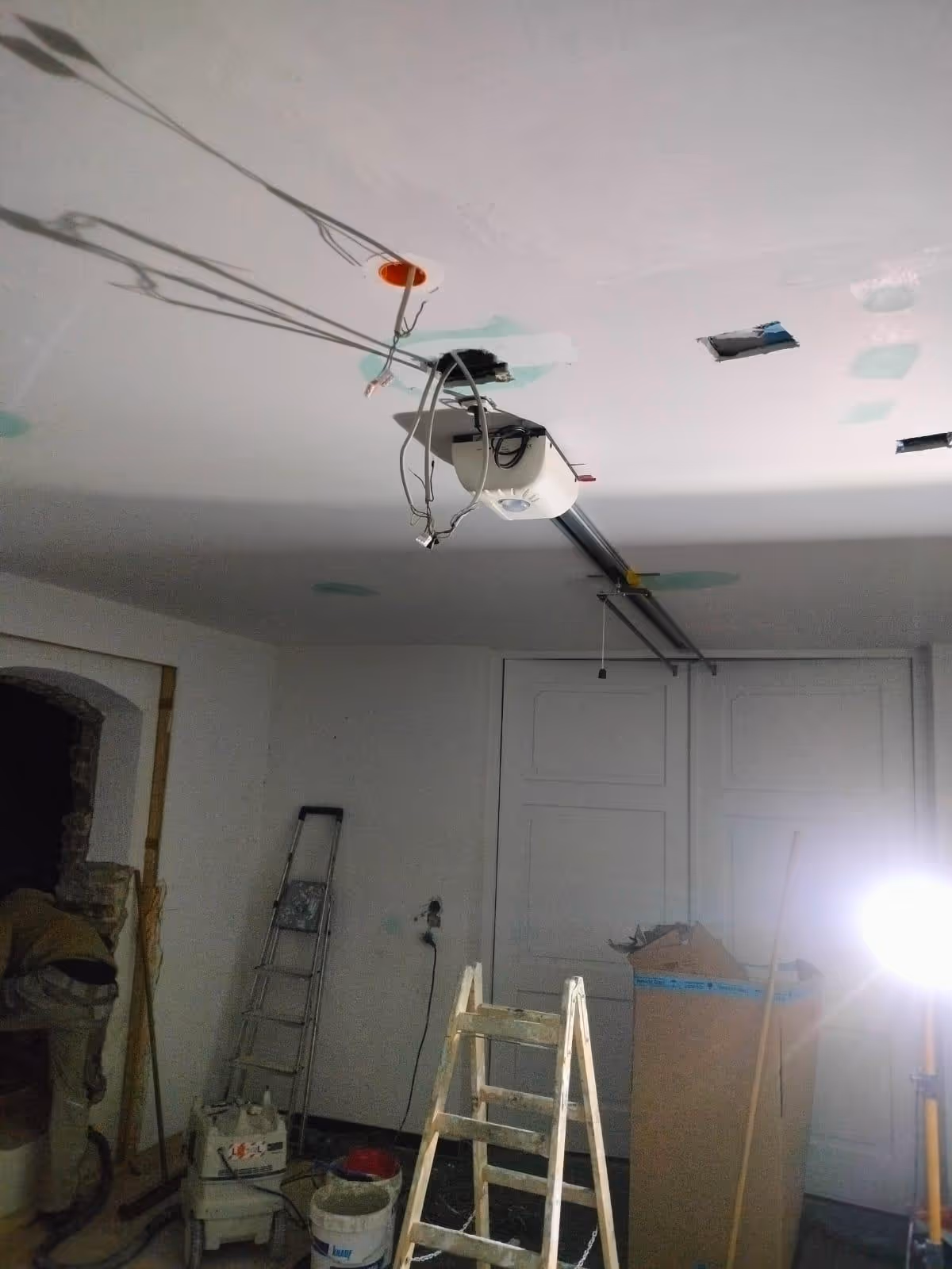 Geöffnete Decke mit Kabeln, Leitern und Baustrahler während des Garagenausbaus in Augsburg
