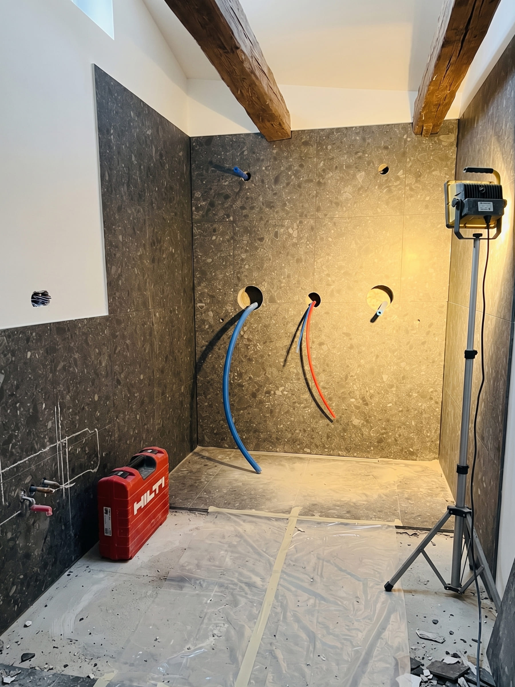 Neue Wasser- und Elektroanschlüsse an der Wand in Steinoptik während des Umbaus der Scheune in Augsburg