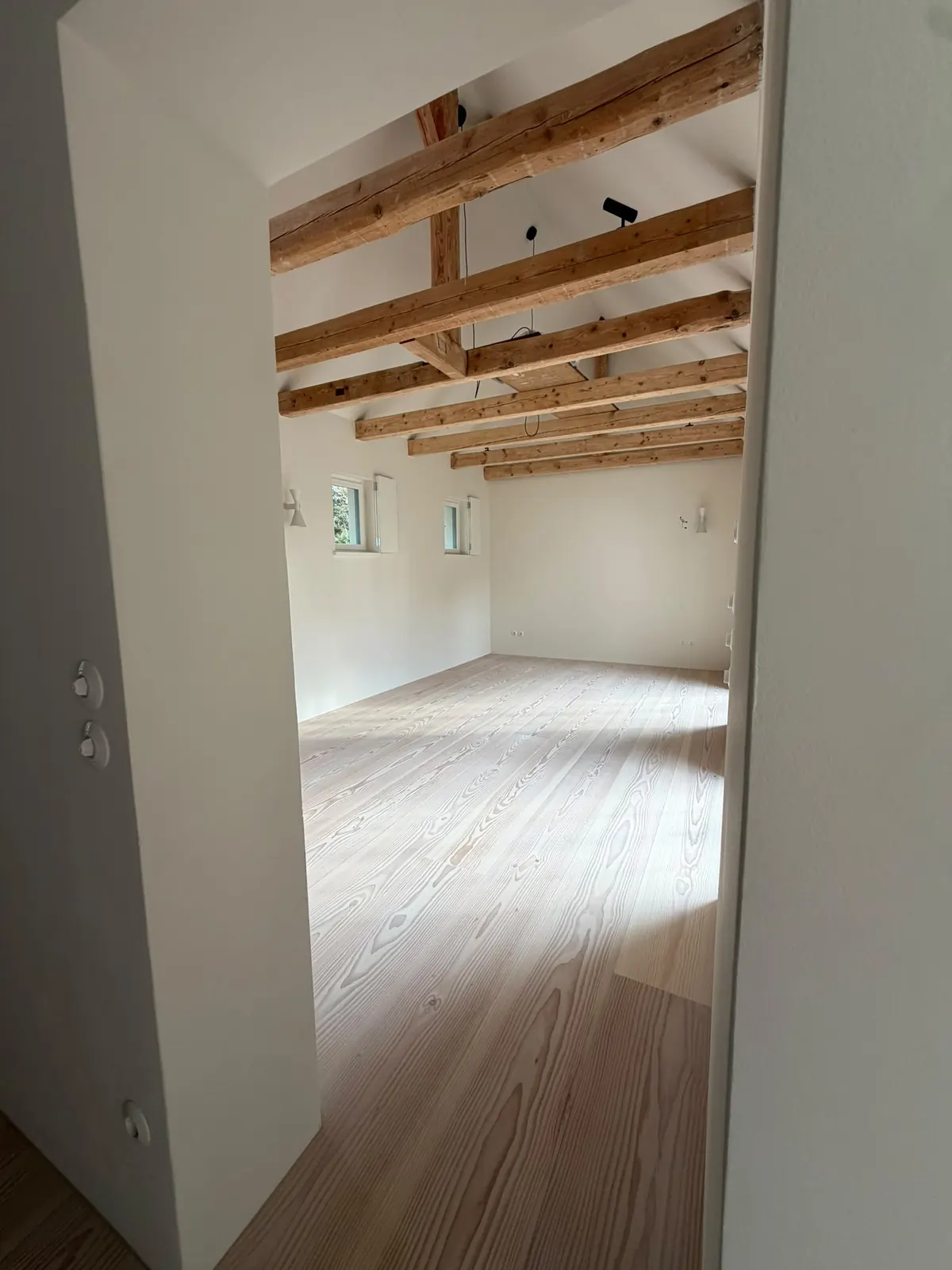 Durchgang ins Dachgeschoss mit Holzbalken und Holzdielen im Haus am Pilsensee