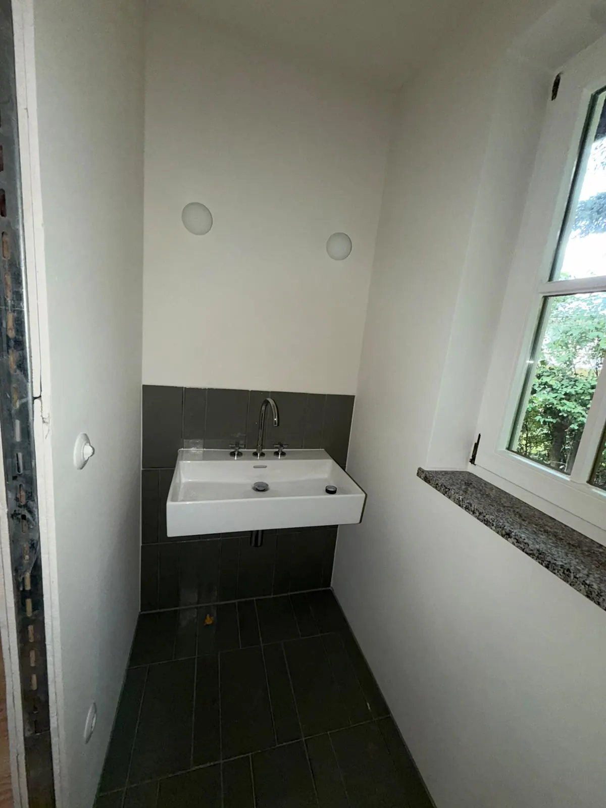 Gäste-WC mit Waschbecken und Fenster im Erdgeschoss am Pilsensee