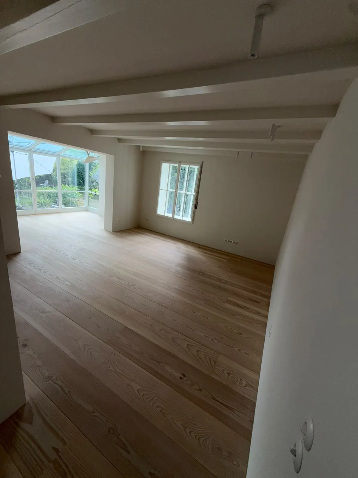 Erdgeschoss mit neuem Holzboden und Wintergarten im sanierten Haus am Pilsensee