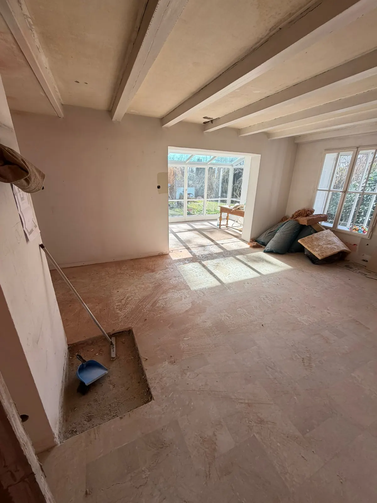 Haus am Pilsensee während der Sanierung: Erdgeschoss mit freigelegtem Boden und Blick zum Wintergarten