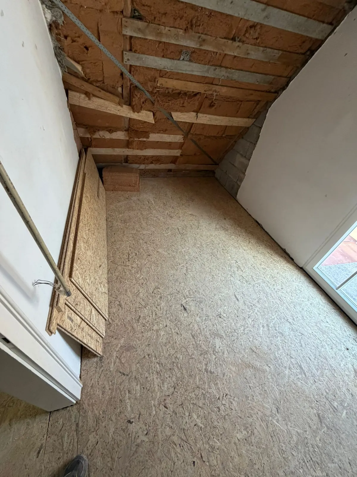 Dachgeschoss des Hauses am Pilsensee während der Sanierung: offene Dachschräge und Holzwerkstoffboden im künftigen Schlafzimmer