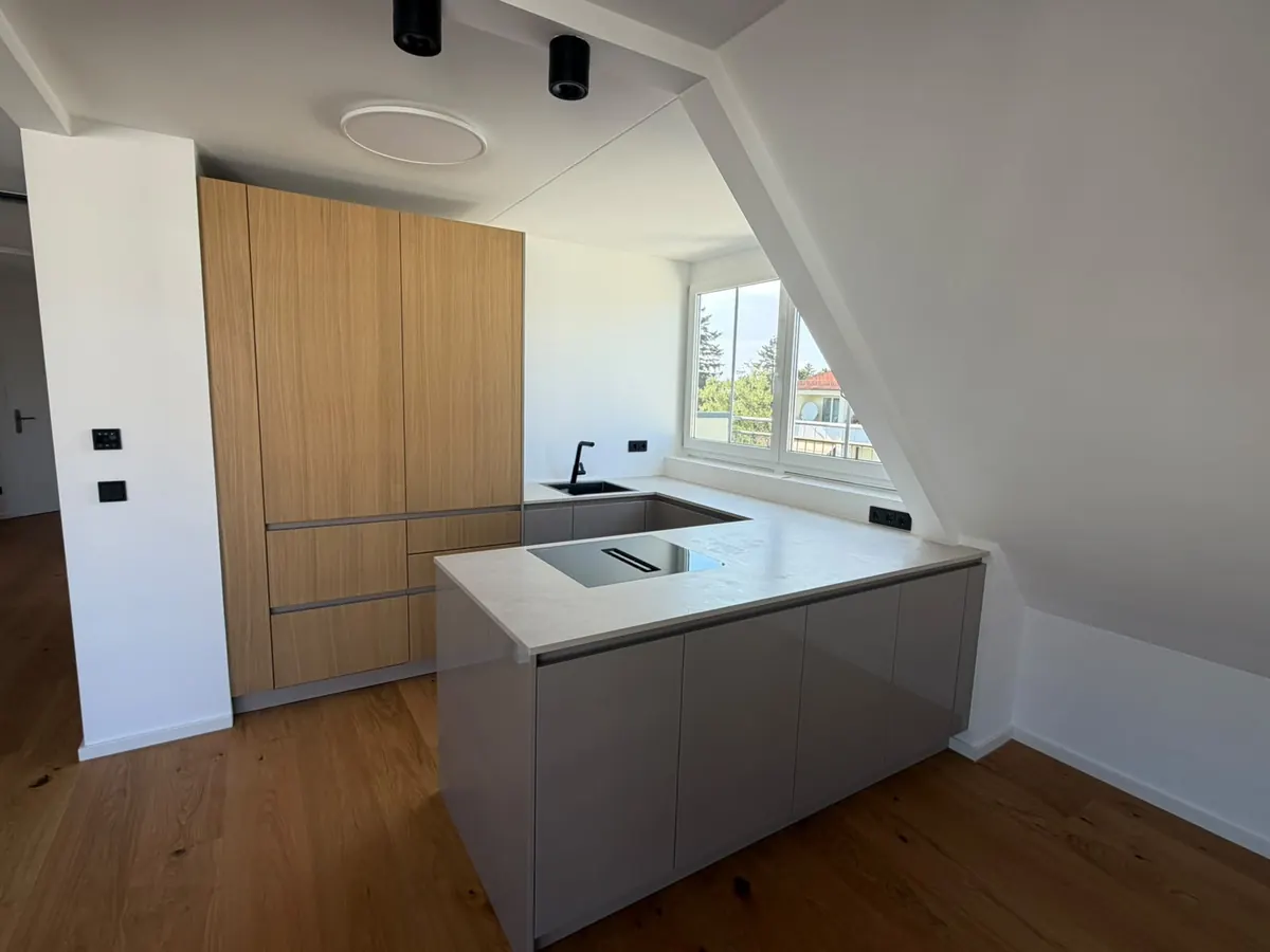 Offene Küche mit Kochinsel und Einbauschränken in der sanierten Wohnung in Sendling