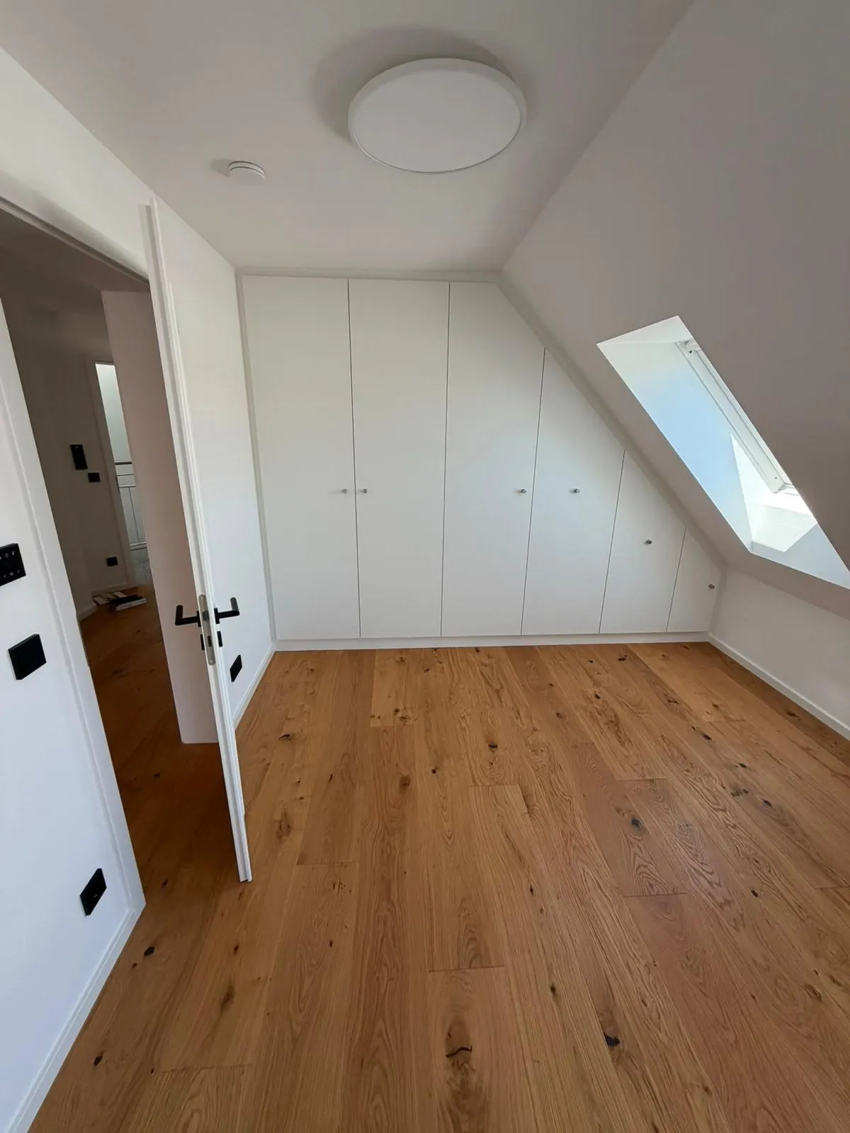 Zimmer mit Einbauschrank, Dachfenster und Eichenparkett