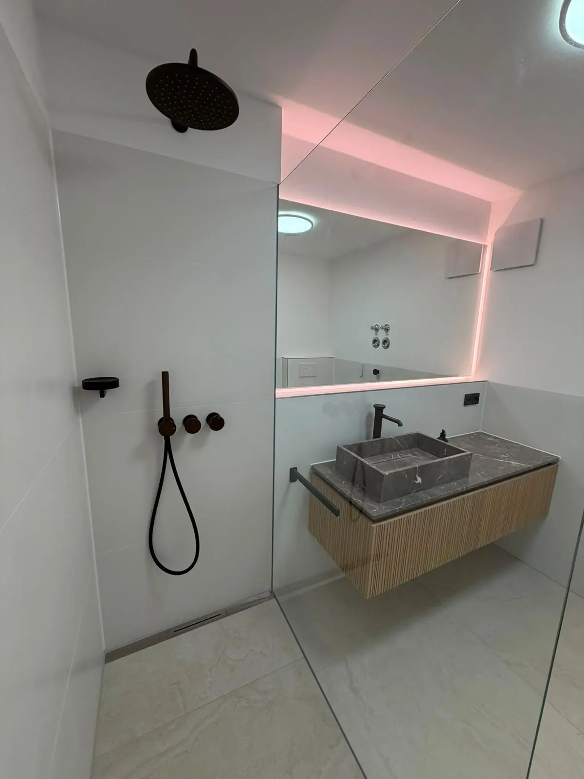Fertiges Badezimmer der Wohnung in München-Sendling mit bodengleicher Dusche und Waschtisch