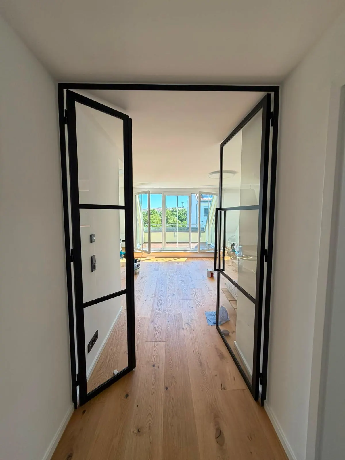 Neue Lofttür aus Stahl und Glas an der Stelle des alten Durchgangs, Blick vom Flur in den Wohnraum